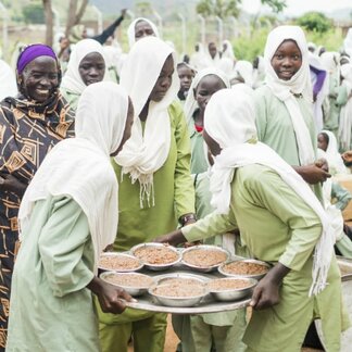 School children with a tray of hot and nutritious meal