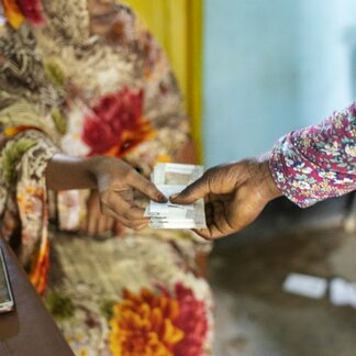 Woman receiving cash assistance from WFP staff