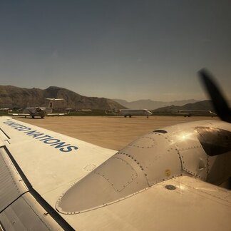 An UNHAS plane moving along a runway.