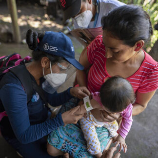 Glendy, a nutritionist, uses a mid-upper arm circumference band to measure the levels of malnutrition of a baby girl during a visit of the Nutrition and Health Brigades to homes in Malacatán, department of San Marcos, Guatemala. Glendy is the leader of the nutrition brigades in Malacatán, whose members are locally known “brigadistas”.