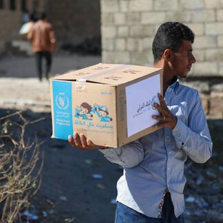 Man carrying a box of WFP food