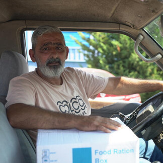 A beneficiary with his food ration box in Beirut