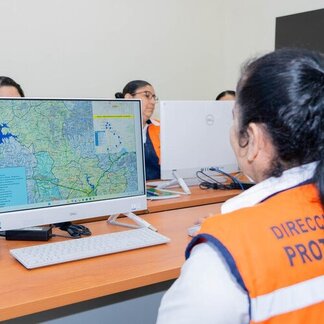 Woman working on a computer looking at a map