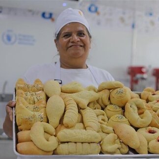Woman showing a tray of baking