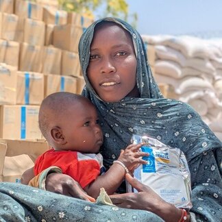 A mother and child with formulated nutritious food at a WFP distribution site. 