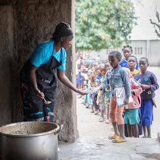 Students receiving their daily homegrown school meals at the Primary School of Nhacapiriri in the district of Cahora Bassa, Tete province