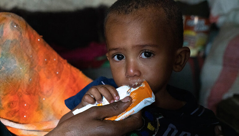 Yemen. Sultan's mother feeds him a nutritious peanut paste at home. He suffers from moderate acute malnutrition. Thanks to the supplementary food he is receiving from WFP, Sultan has started to gain weight and has more energy than before. But he still needs treatment. His family also receive WFP food assistance - flour, dried beans, oil, sugar and salt. WFP/Mohammed Awadh