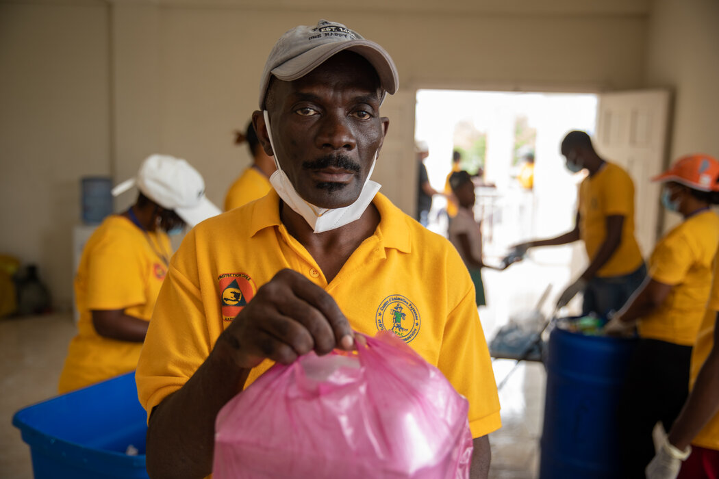 A miembro del personal del WFP sostiene una bolsa rosa de alimentos