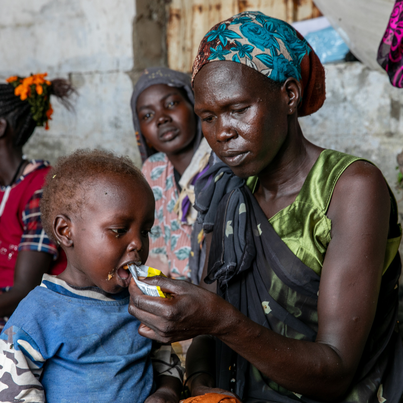 Aker, 32, feds her child at a transit centre in South Sudan - over 350,000 people have crossed into South Sudan from Sudan since the conflict broke out in April 2023.