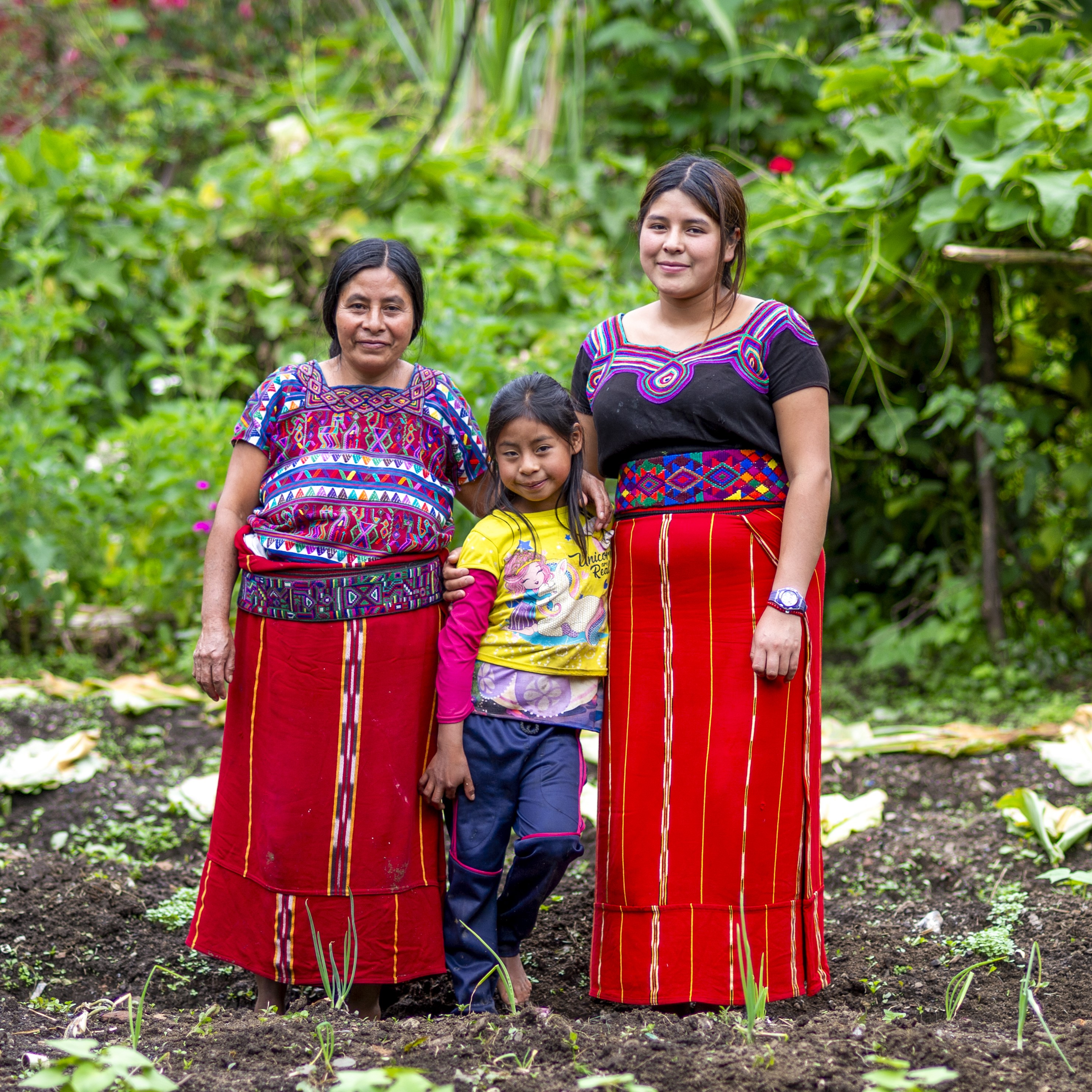  Maria poses with two of her daughters, Petronila, and Elena Lucrecia (9), in their family field near their home in the Cocop community of Nebaj municipality, Quiché, Guatemala, on 4 August 2023.