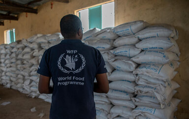 Photo: WFP/Gemma Snowdon A WFP employee looks at bags of food items before distribution at a general food distribution site in the village of Maikona in Marsabit County, northern Kenya