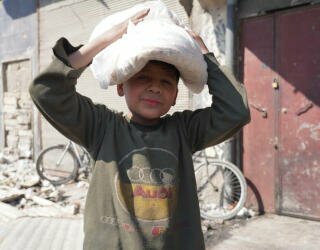 Syria, Aleppo. Children join their parents in line, or are sent to collect bread alone before going to school. Photo: WFP/Hussam Al Saleh