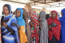 Photo: WFP/Leni Kinzli. women waiting in line to receive cash distributions. 